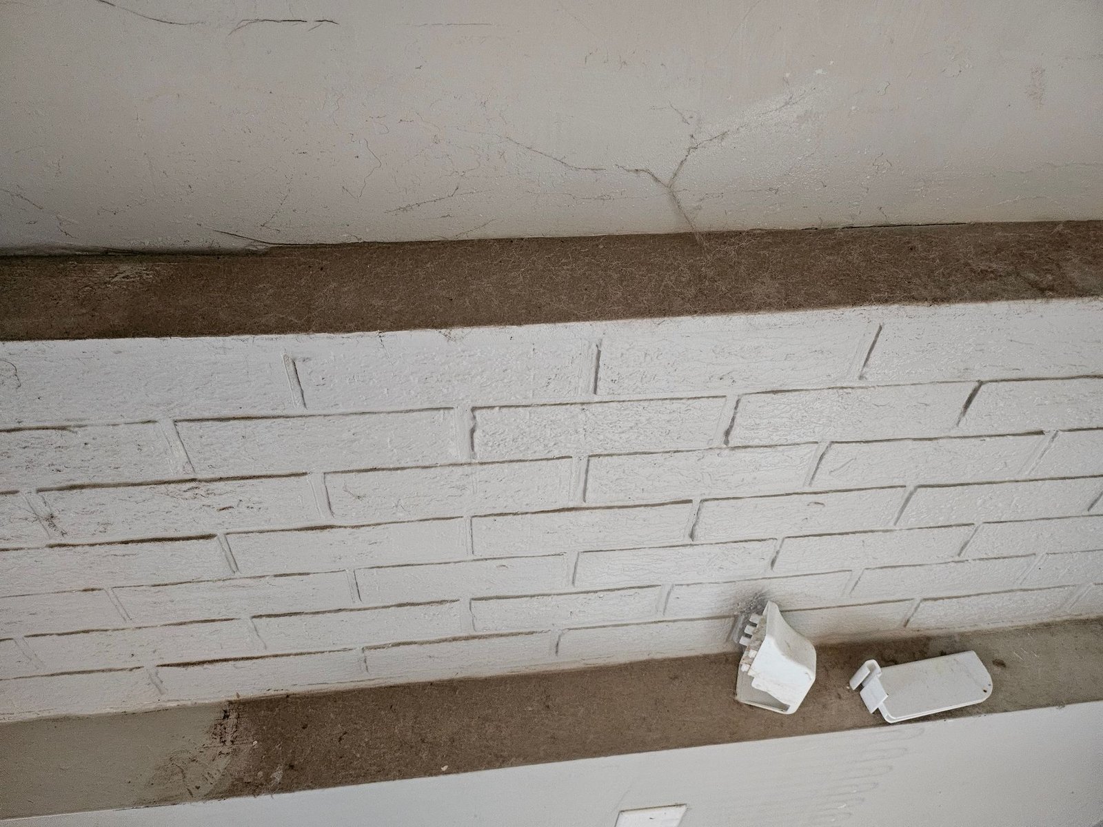 A white brick wall with a few pieces of styrofoam on it