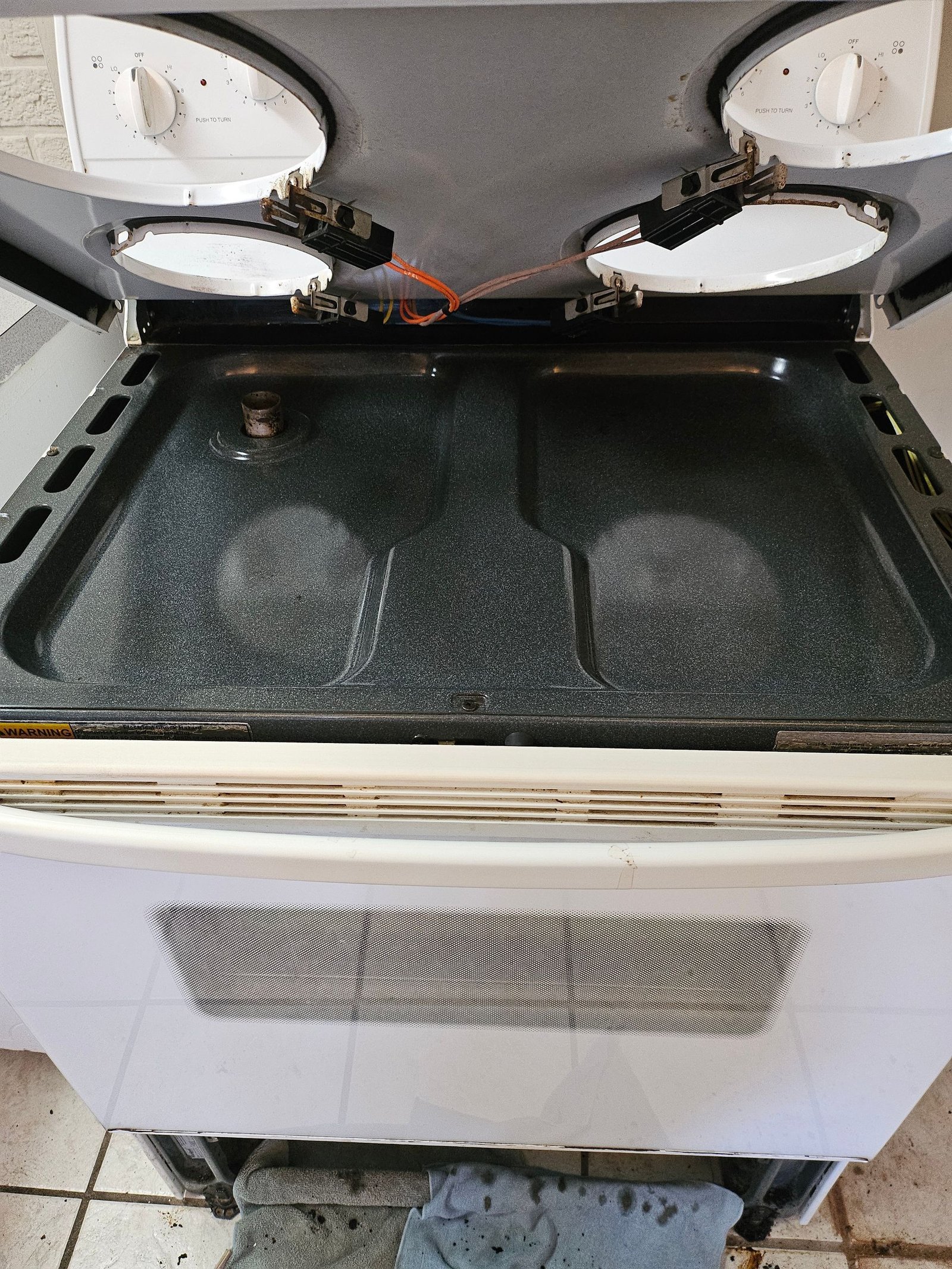 A white stove top oven with the door open