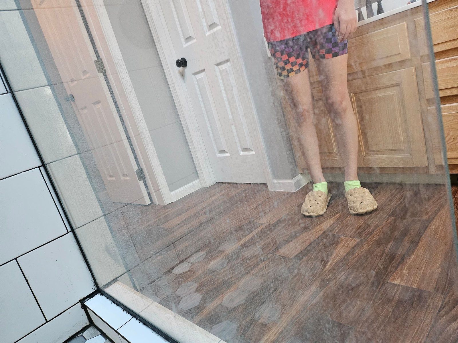 A person is standing in front of a mirror in a bathroom.