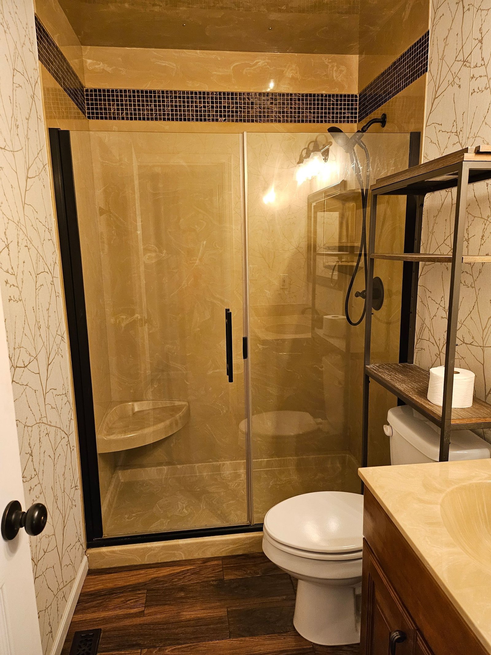 A bathroom with a toilet, sink, shower and glass door.