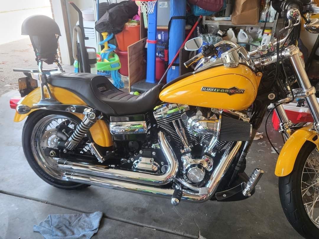 A yellow harley davidson motorcycle is parked in a garage.